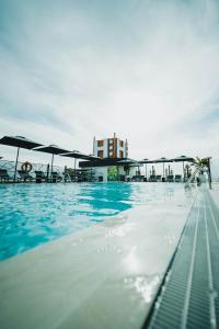 una piscina con agua azul y sombrillas en Hotel Málaga Nostrum Airport en Málaga