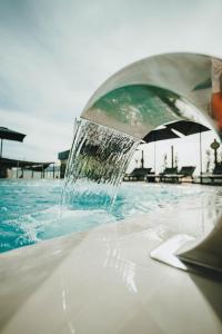 una persona está vertiendo agua en una piscina en Hotel Málaga Nostrum Airport en Málaga