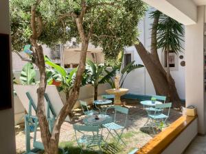 a patio with tables and chairs next to a tree at Tree of Life Art Hotel in Agia Marina Nea Kydonias