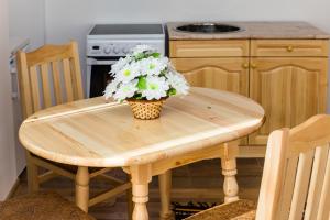 a wooden table with a pot of white flowers on it at Rodopsko Katche in Alamovtsi