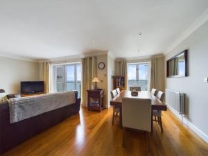 a living room with a couch and a dining room table at Cosy 3 bedroom apartment in central Portrush with sea views in Portrush