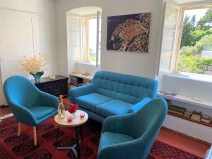 a living room with a blue couch and two chairs at Bonaca apartment and rooms in Dubrovnik