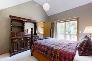 a bedroom with a bed and a dresser and a mirror at Chalet Gibby in Killington