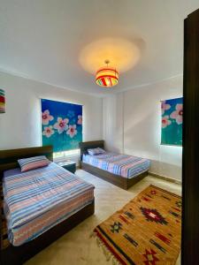 Postel nebo postele na pokoji v ubytování Amwaj Prime Chalet with a Sea View شاليه أمواج الساحل الشمالي السعر شامل شحن الكهرباء و المياه و الأستعلام الأمني وغير شامل شحن كروت الإيجار + 11 fotografií