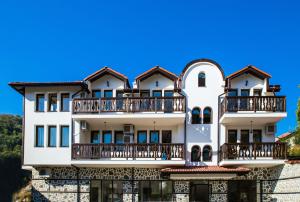 a white building with balconies on it at Rodopsko Katche in Alamovtsi
