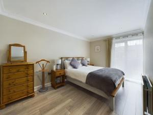 a bedroom with a bed and a dresser and a mirror at Cosy 3 bedroom apartment in central Portrush with sea views in Portrush