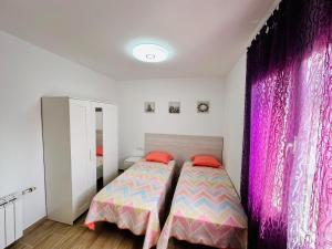 Villa “Castellón“ في ميامي بلاتجا: غرفة نوم بسرير وستائر وردية