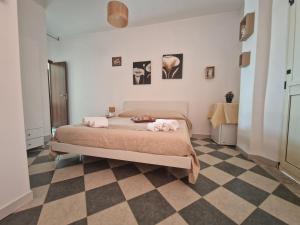 a bedroom with a bed and a checkered floor at Santa Venere Apartments "Parcheggio privato" in Tropea