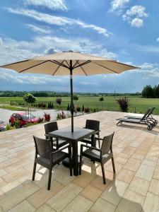 einen Tisch und Stühle mit Sonnenschirm auf einer Terrasse in der Unterkunft Magurska Panorama 