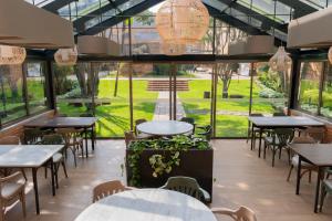 un restaurante con mesas, sillas y ventanas en Hotel Habitel Prime en Bogotá