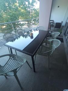 einen schwarzen Tisch und Stühle auf dem Balkon in der Unterkunft La Alameda Jardines del Prado -Amplio y con ascensor- in Talavera de la Reina