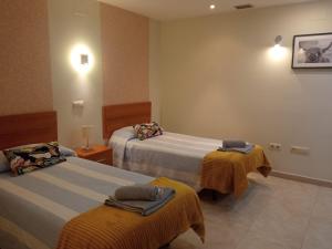 Habitación de hotel con 2 camas y toallas. en La Alameda Jardines del Prado -Amplio y con ascensor-, en Talavera de la Reina