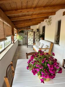 a dining room with a table with flowers on it at Il Nido dei Venti in Tempio Pausania