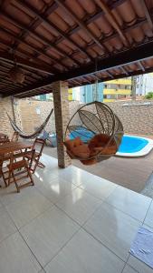 een patio met een hangmat en een tafel en stoelen bij Casa de Férias á 400m pra Praia de Cabo Branco in João Pessoa