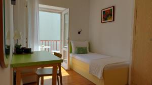 a bedroom with a bed and a desk and a window at Guest House Mediterranean in Hvar