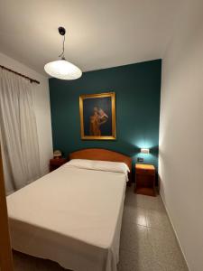 Baia VerdeにあるI love Baia Verde & spaのベッドと壁に絵が飾られた寝室