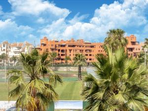 a large building with palm trees in front of it at Spacious Holiday Home in Motril with 2 Large Terraces in Motril