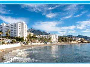 a view of a beach with buildings and the ocean at Apartamento TORRESOL NSFA - TORRECILLA, NERJA - studio in Nerja