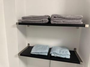 a black shelf with towels on it in a bathroom at Zentrale, stilvolle Wohnung in Lübeck +26 photos