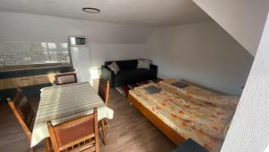 a bedroom with a bed and a couch and a table at Városi Kuckó in Odorheiu Secuiesc