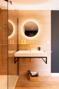 ein Badezimmer mit Waschbecken und Spiegel in der Unterkunft COCON NOELY 1 in Toulouse