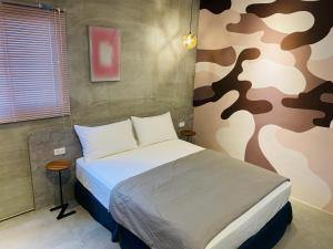 1 dormitorio con 1 cama con una pared de temática militar en 夏至文旅 Midsummer Guest House, en Magong