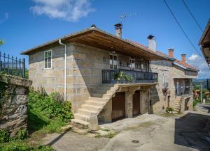 Olás de VillariñoにあるApartamentos Turísticos Casa dos Pulidosのバルコニーと階段が備わるレンガ造りの家です。