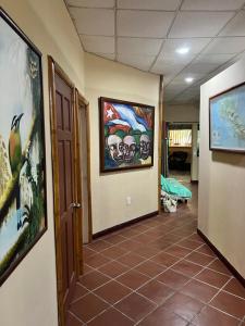 un pasillo con pinturas en las paredes y suelo de baldosa en Casa Manglar Villa, en Puerto Jiménez