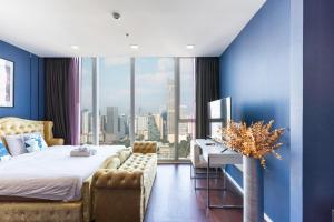 a bedroom with a bed and a desk and a large window at Skyline Suites Sukhumvit 11 in Bangkok