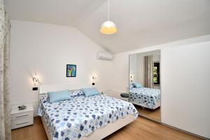 a white bedroom with a bed and a mirror at House Ariella in Umag