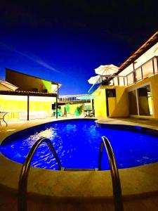 Pousada Gente Bonita La Mansion في بوزيوس: مسبح ازرق كبير امام المنزل