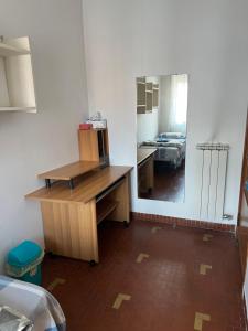 a room with a desk with a mirror and a bedroom at 旅途之家 in Mestre