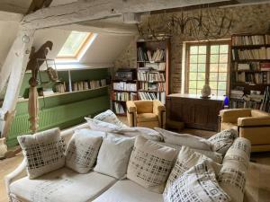 a living room with a white couch with pillows at Maison Nomade Perche - MaisonNomadeChic in Cour-Maugis-sur-Huisne