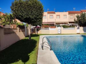a swimming pool in a yard next to a building at Casa La Higuera in Retamar