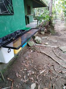 uma grelha sentada do lado de fora de uma casa na terra em Chosa Manglar Suites em Puerto Jiménez