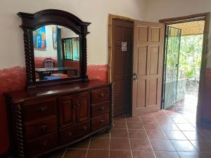 a wooden dresser with a mirror on top of it at Chosa Manglar Suites in Puerto Jiménez