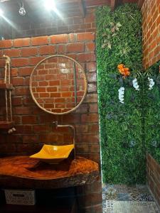 a bathroom with a mirror on a brick wall at Chalé Da Pecan in Anta Gorda