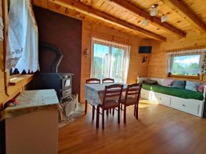 a dining room with a table and chairs and a bed at Domek na Grządce in Bieńkówka