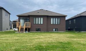 a house with a wooden deck in a yard at Beartice Beach House in Wasaga Beach