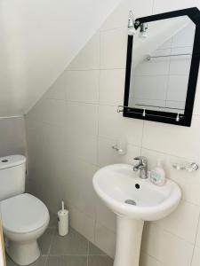 bagno con lavandino, servizi igienici e specchio di Vitamin Sea a Sarandë