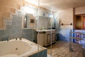 a bathroom with a tub and a sink at Cà delle glicini in Paruzzaro +7 photos