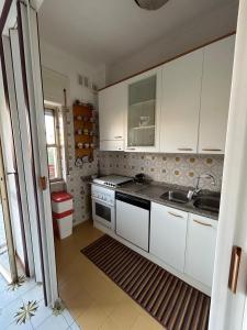a kitchen with white cabinets and a sink at A casa di Serafino in Formia