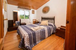 Olás de VillariñoにあるApartamentos Turísticos Casa dos Pulidosのベッドルーム1室(青と白の毛布付きのベッド1台付)