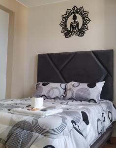 a bedroom with a bed with a black and white comforter at Hospedaje Mónaco - Jauja Airport in Jauja