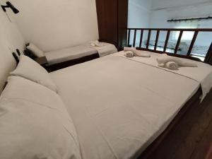 two twin beds in a room with a window at Almmos Mezzanine Apartments 2 in Kalamaki Heraklion