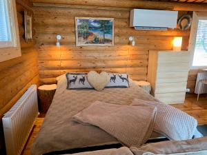 Dormitorio con cama con almohada de corazón en Kaupinmaja, Ylläs, Äkäslompolo, Lapland - Log Cabin with Lake and Fell Scenery, en Äkäslompolo