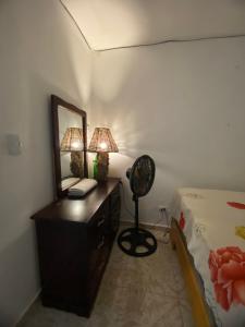 Dormitorio con tocador con espejo y cama en Watermelon House, en Santa Bárbara de Samaná