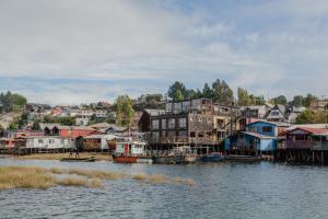 卡斯特羅的住宿－Palafito 1326 Hotel Boutique Chiloé，一群房子,靠近水体