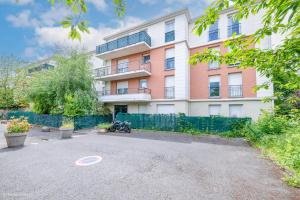 an apartment building with a driveway in front of it at Pilepoal II - Balcon - Parking - 6Pers - Lumineux in Villemomble