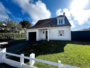 a white house with a fence in a yard at L'Aparté à 5min de la plage de Hardelot in Neufchâtel-Hardelot